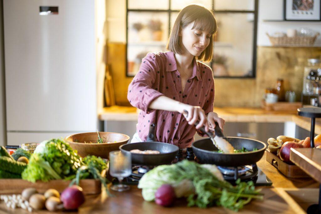 Frau beim Kochen mit Zutaten auf der Arbeitsfläche